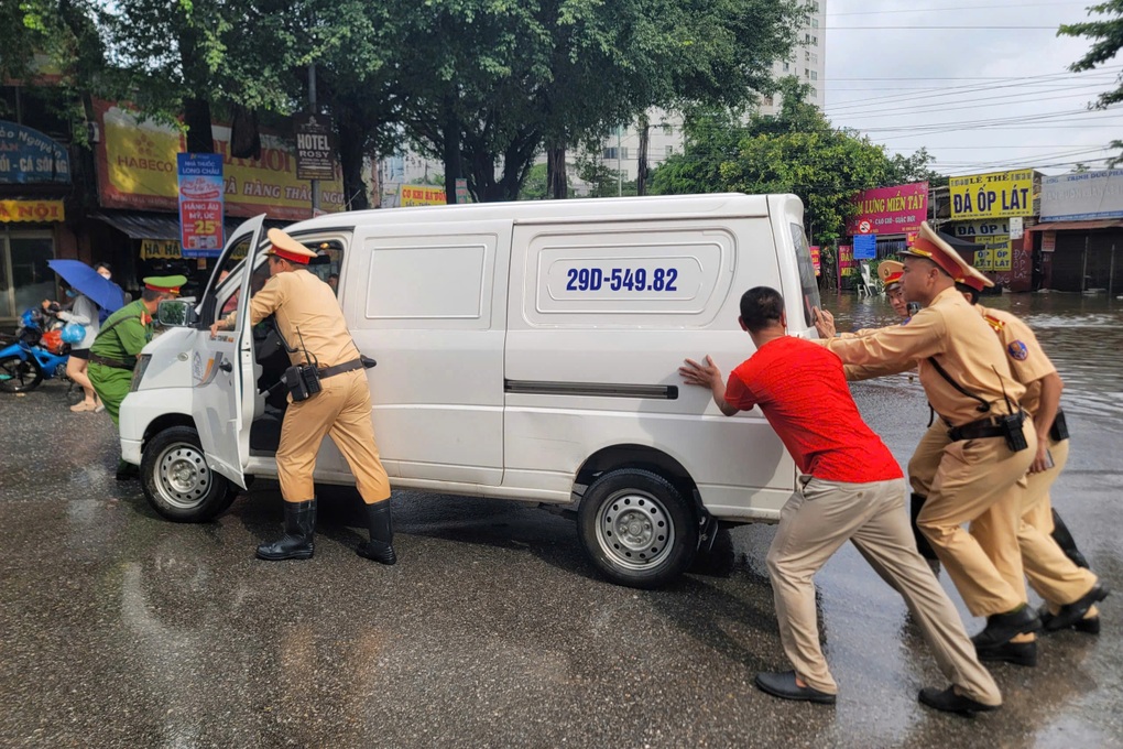 Cảnh sát giao thông Hà Nội huy động tối đa lực lượng hỗ trợ người dân vượt qua các điểm ngập úng- Ảnh 1.