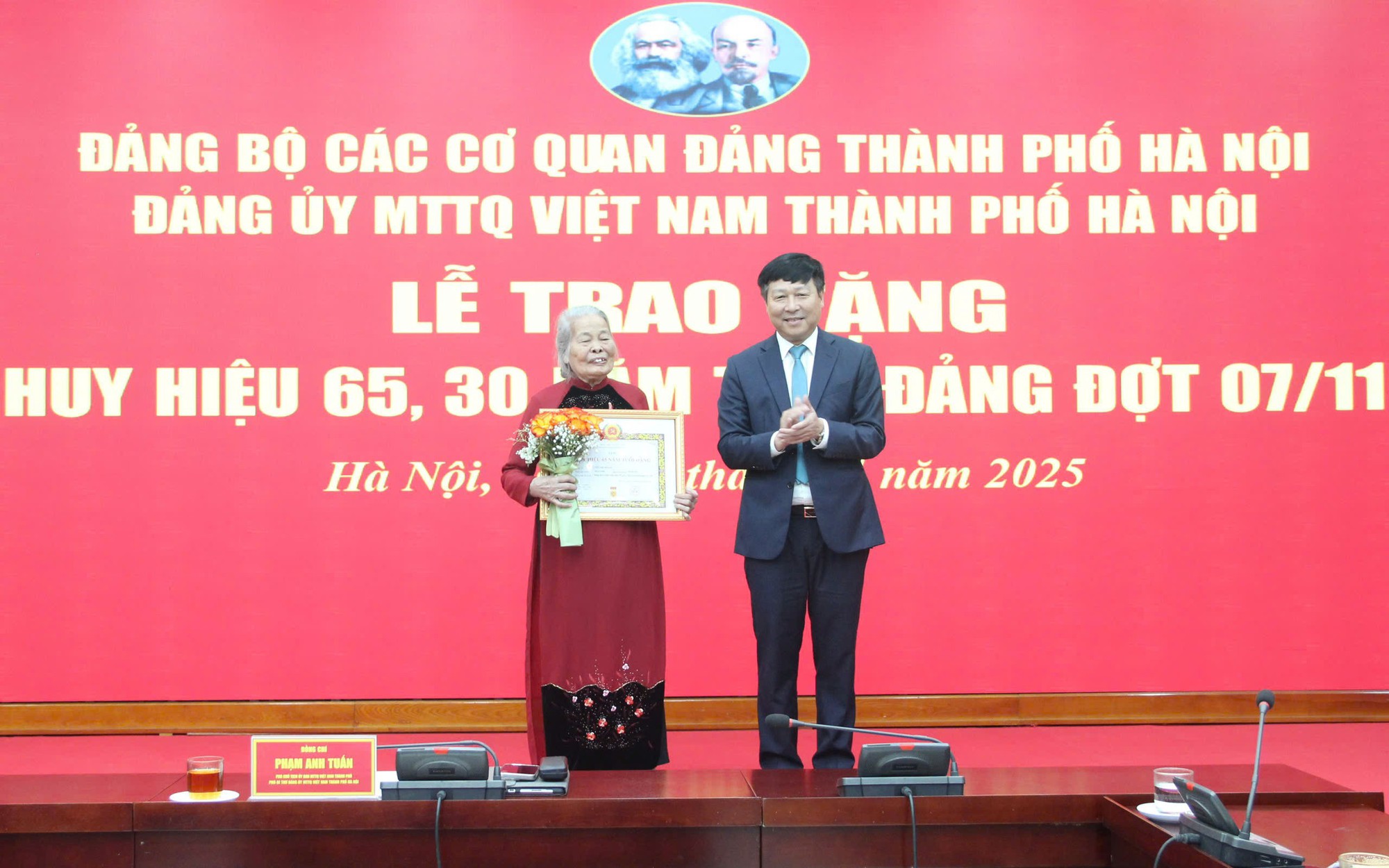 Phó Chủ tịch Thường trực Ủy ban MTTQ Việt Nam thành phố Hà Nội Phạm Anh Tuấn trao Huy hiệu Đảng tặng đảng viên lão thành.