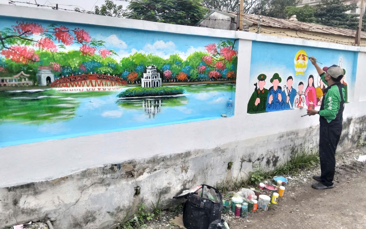 Ludzie dekorują murale w domu spotkań Grupy Mieszkaniowej nr 6. Người dân đang trang trí các bức tranh tường tại nhà hội họp Tổ dân phố số 6