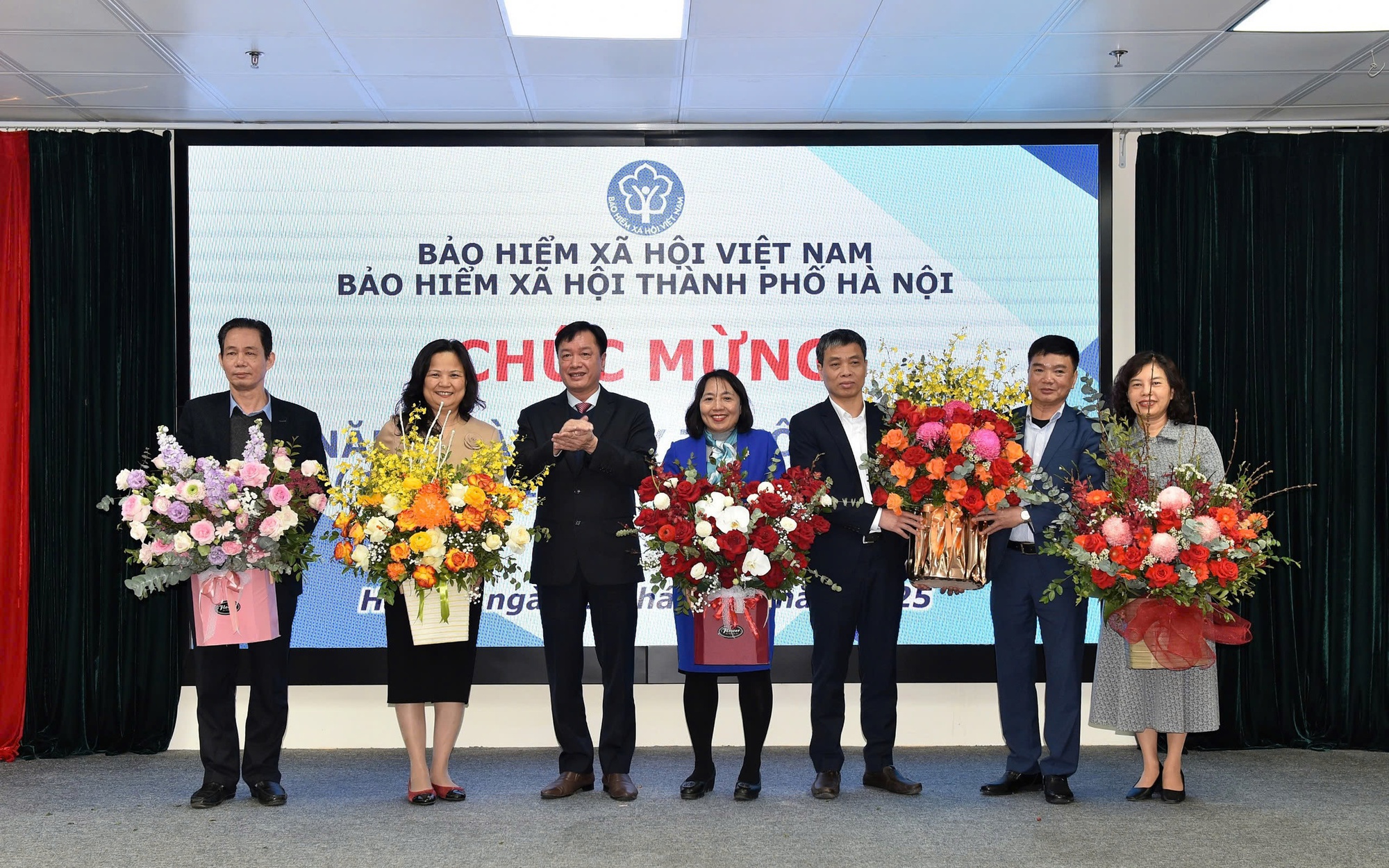 Giám đốc BHXH thành phố Hà Nội Phan Văn Mến tặng hoa chúc mừng các y bác sĩ, cán bộ làm công tác giám định BHYT