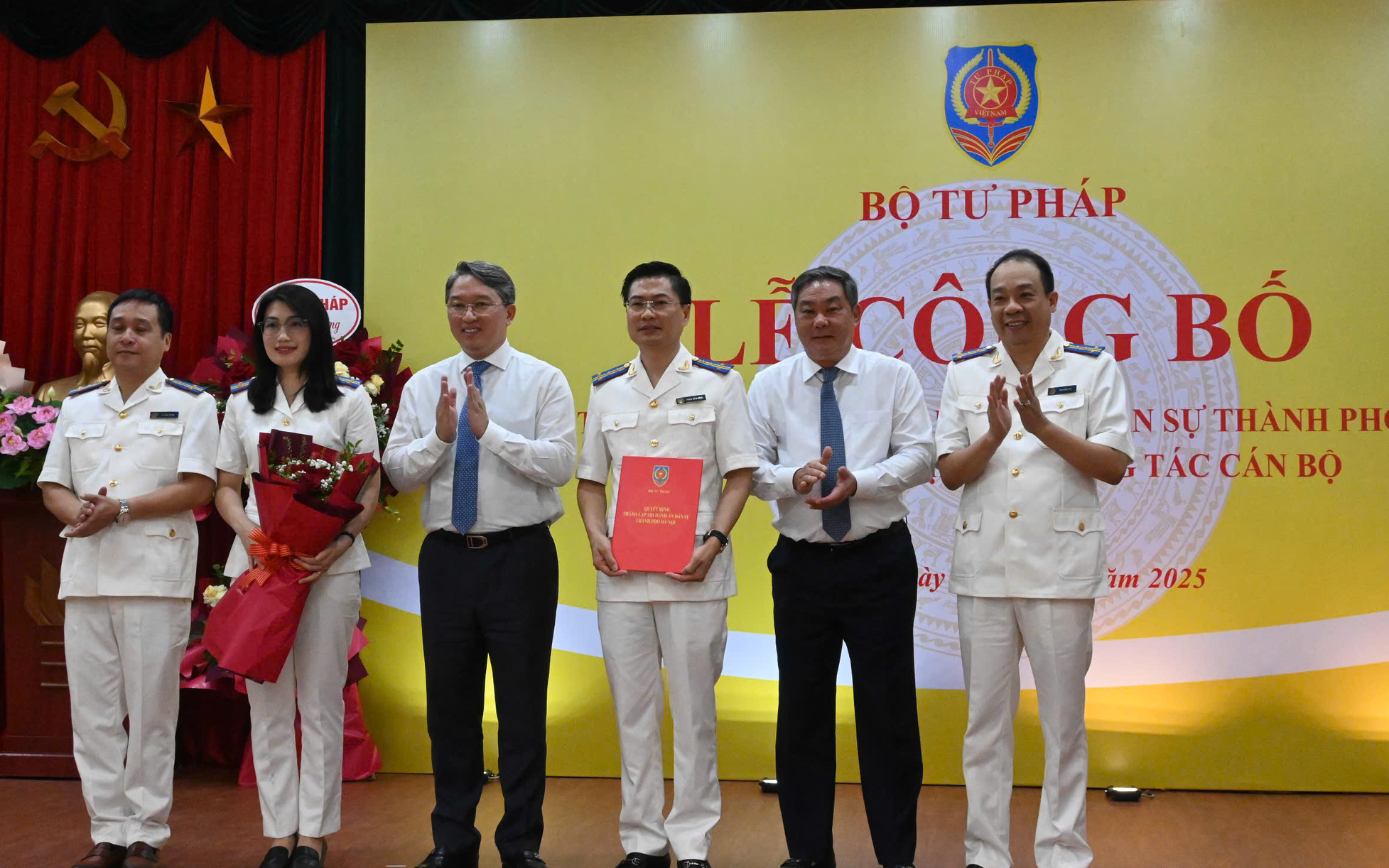 Các đồng chí: Nguyễn Hải Ninh, Ủy viên Ban Chấp hành Trung ương Đảng, Bộ trưởng Bộ Tư pháp; Lê Hồng Sơn, Ủy viên Ban Thường vụ Thành ủy, Phó Chủ tịch Thường trực UBND thành phố Hà Nội trao quyết định và tặng hoa chúc mừng Thi hành án dân sự thành phố Hà Nội