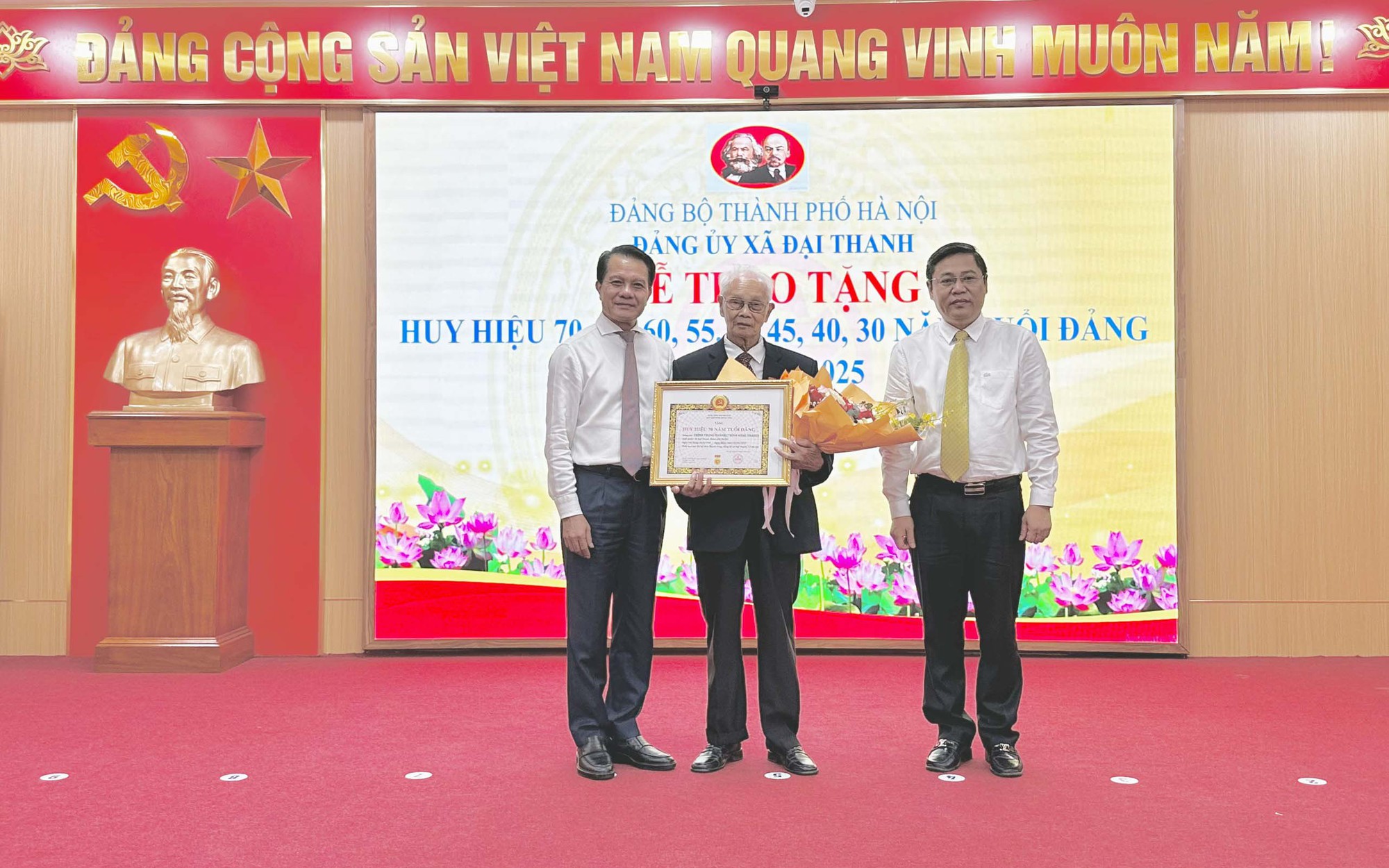 Chủ nhiệm Ủy ban Kiểm tra Thành ủy Hà Nội Hoàng Trọng Quyết và Bí thư Đảng ủy, Chủ tịch HĐND xã Đại Thanh Đặng Đức Quỳnh trao Huy hiệu 70 tuổi Đảng tặng đảng viên