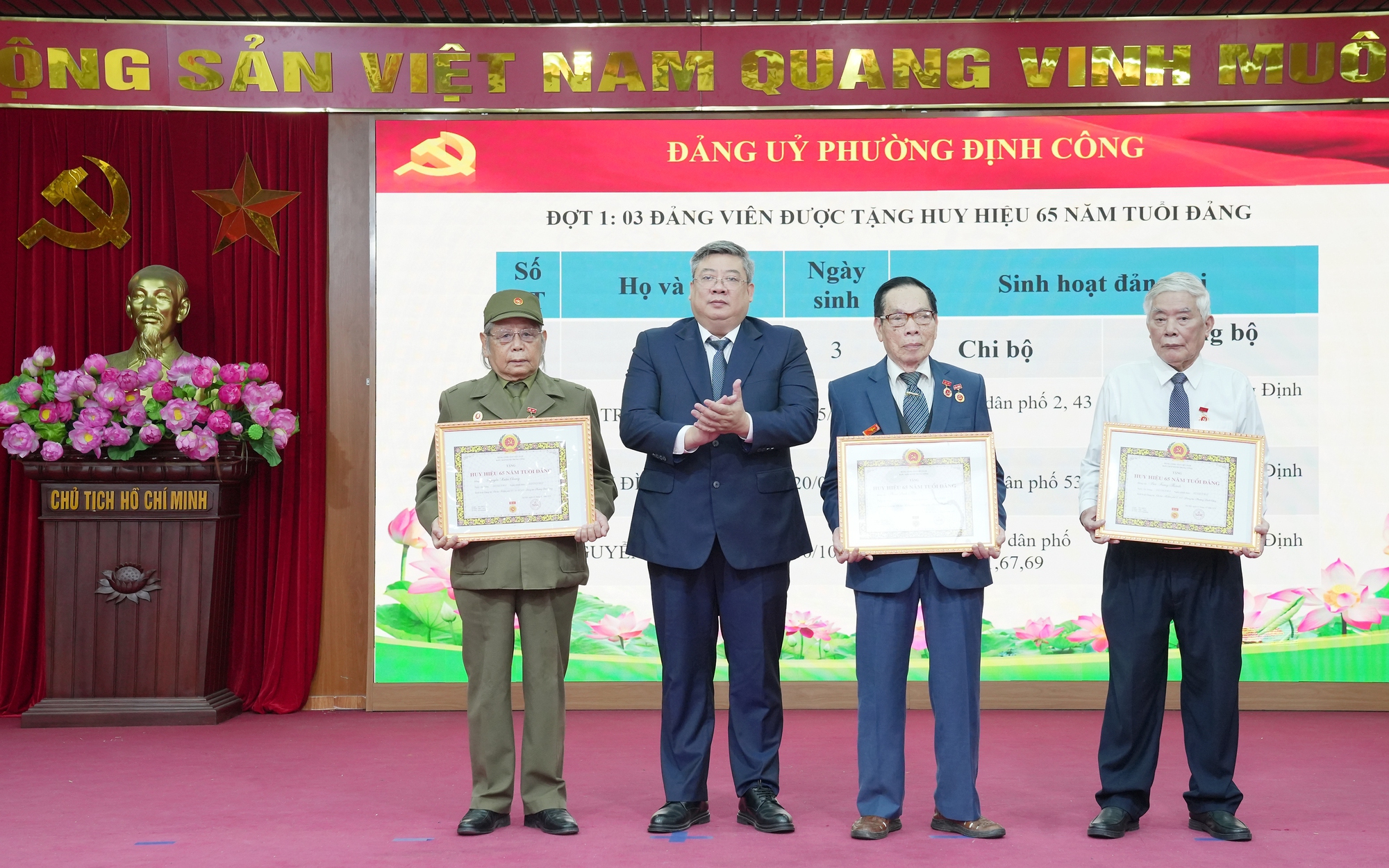 Bí thư Đảng ủy, Chủ tịch HĐND phường Định Công Nguyễn Quang Trung trao huy hiệu 65 năm tuổi Đảng tặng các đảng viên