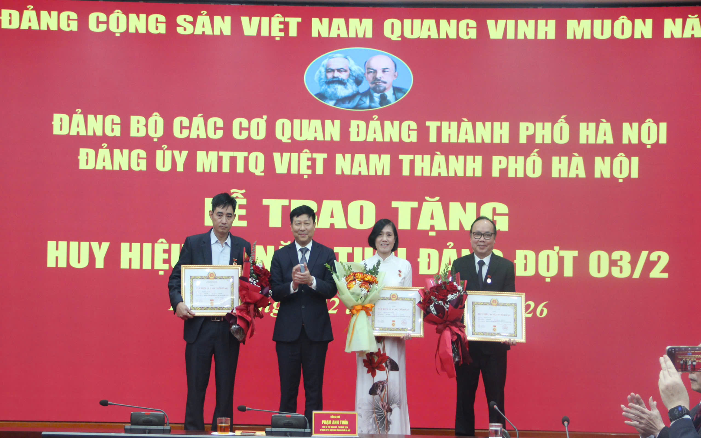 Phó Bí thư Đảng ủy, Phó Chủ tịch Ủy ban MTTQ Việt Nam thành phố Hà Nội Phạm Anh Tuấn trao Huy hiệu 30 năm tuổi Đảng tặng các đảng viên.