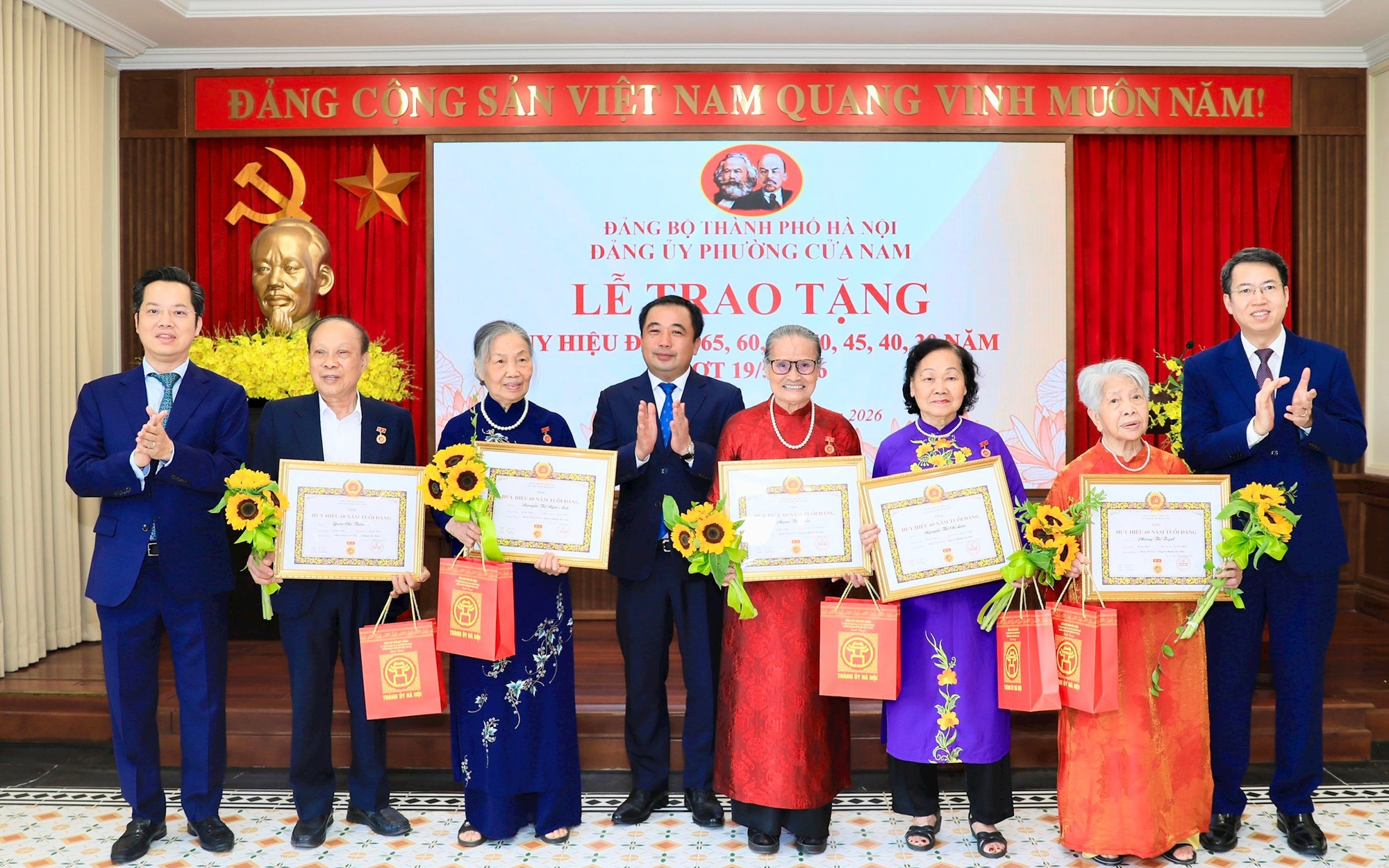 Bí thư Thành ủy Trần Đức Thắng và Trưởng ban Tổ chức Thành ủy Vũ Đăng Định trao Huy hiệu 60 năm tuổi Đảng tặng các đảng viên lão thành. 