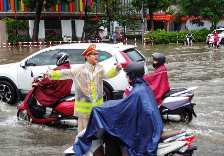 Cảnh sát giao thông Hà Nội căng mình phân luồng, giúp dân trong mưa ngập- Ảnh 2.