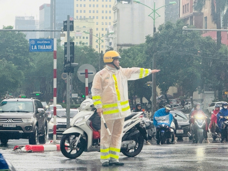 Cảnh sát giao thông Hà Nội căng mình phân luồng, giúp dân trong mưa ngập- Ảnh 6.