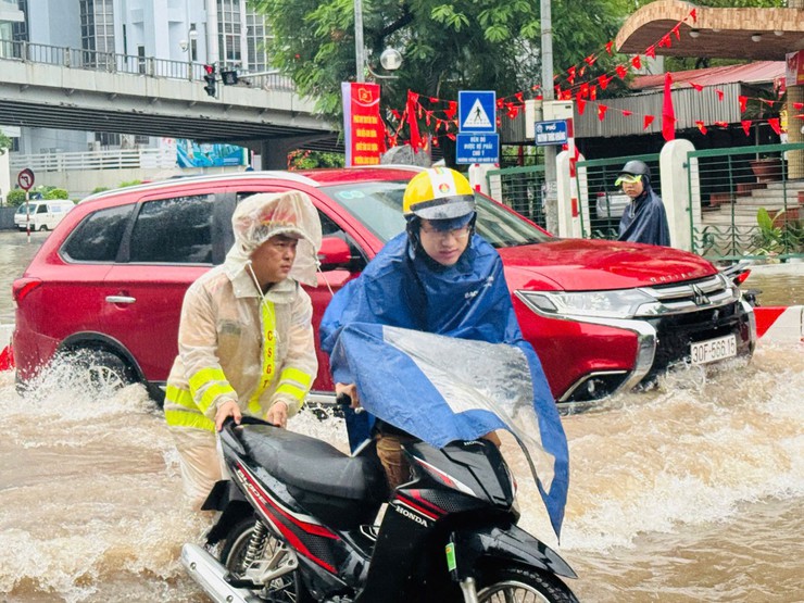 Cảnh sát giao thông Hà Nội căng mình phân luồng, giúp dân trong mưa ngập- Ảnh 3.