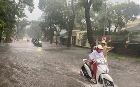 Cảnh sát giao thông Hà Nội căng mình phân luồng, giúp dân trong mưa ngập